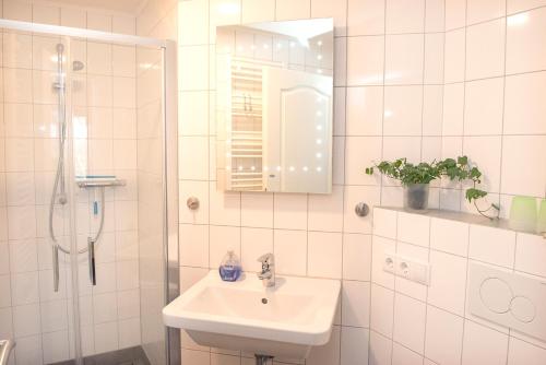 a white bathroom with a sink and a shower at Landgasthof Kasch - Hotel und Restaurant in Timmdorf