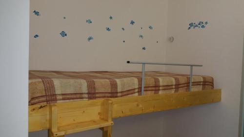 ein Bett in einem Schlafzimmer mit einem Bettrahmen und einer Wand in der Unterkunft Monolocale Calamaiore in La Maddalena