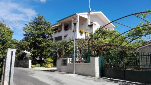 una casa blanca con una valla en una calle en Apartments Villa Martinuzzi, en Rovinj
