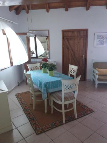 a dining room table with chairs and a blue table cloth at Villa Iviritiko in Nea Roda