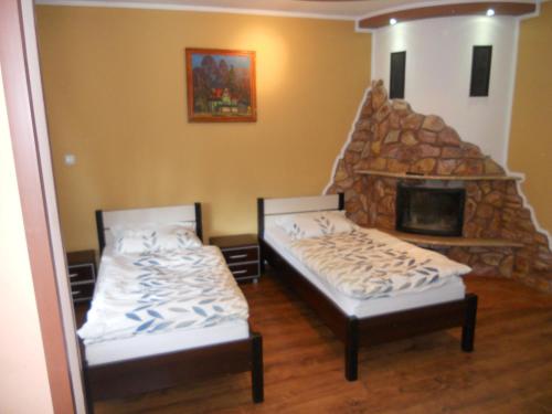 2 camas en una habitación con chimenea de piedra en Apartament Turystyczny w Stepnicy, en Stepnica