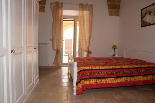 um quarto com uma cama e uma porta para uma janela em Casa Jacqueline al borgo em Giuliano