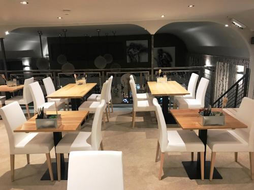 a restaurant with wooden tables and white chairs at The Inn @ Y-Not in Thurso