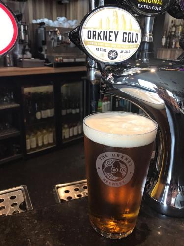 a glass of beer sitting on top of a bar at The Inn @ Y-Not in Thurso