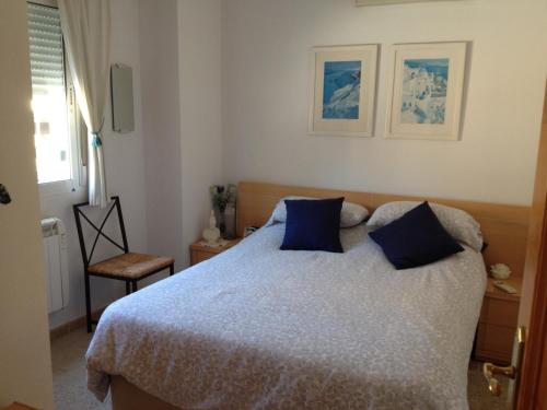 une chambre avec un grand lit avec des oreillers bleus dans l'établissement Pinada del Rio Villa, Alicante, à Tibi