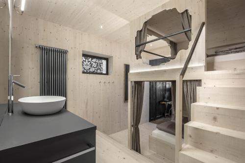 a bathroom with a tub and a sink and a staircase at Artefugium Atelier - Apartments in Selva di Val Gardena