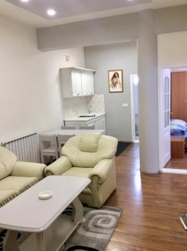 salon z kanapą i stołem w obiekcie Apartman br 4 w mieście Bijeljina