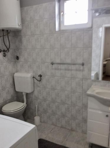 łazienka z toaletą i umywalką w obiekcie Apartman br 4 w mieście Bijeljina