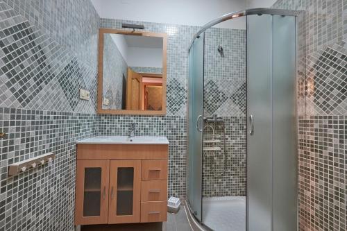 ein Bad mit einer Dusche, einem Waschbecken und einem Spiegel in der Unterkunft ToledoRooms Estrella - M, L, XL, XXL - Pisos con Azotea - Sun Terrace in Toledo
