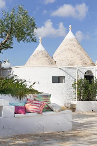 a white building with pillows on a couch with two towers at Tenuta del Lauro in Locorotondo