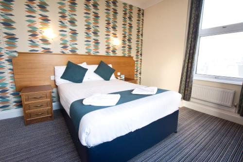 um quarto de hotel com uma cama e uma janela em TLH Victoria Hotel - TLH Leisure, Entertainment and Spa Resort em Torquay