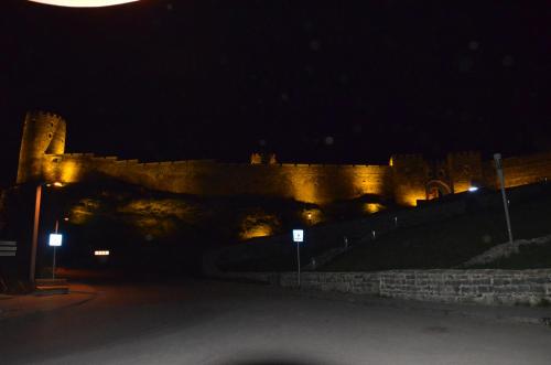 a castle at night with a moon in the sky at Light House Old City in Akhaltsikhe