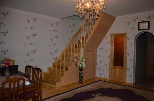 a living room with a staircase and a vase of flowers at Light House Old City in Akhaltsikhe