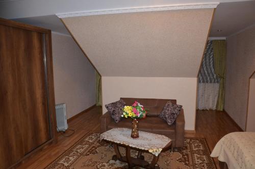 a living room with a couch and a table with flowers at Light House Old City in Akhaltsikhe