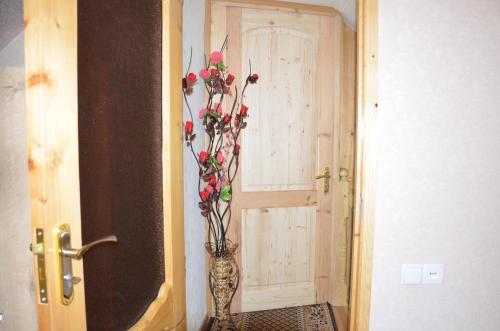 a vase with flowers in it next to a door at Light House Old City in Akhaltsikhe