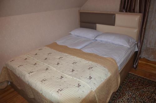 a bedroom with a bed with a white bedspread at Light House Old City in Akhaltsikhe