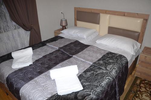 a bedroom with a large bed with two pillows at Light House Old City in Akhaltsikhe