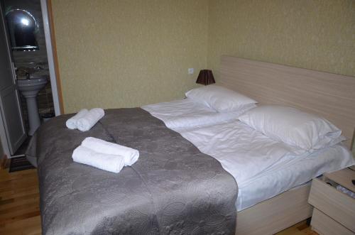 a bed with two pillows and towels on it at Light House Old City in Akhaltsikhe