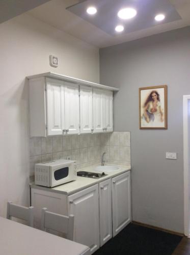 cocina con armarios blancos y microondas en Apartman br 4, en Bijeljina