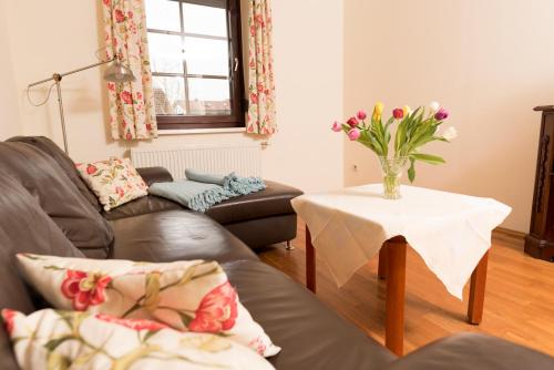 a living room with a couch and a table with a vase of flowers at Gasthof Pension Rabl in Völkermarkt