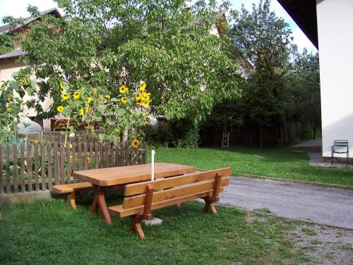 a wooden bench sitting in the grass next to a fence at Mairhof in Laion