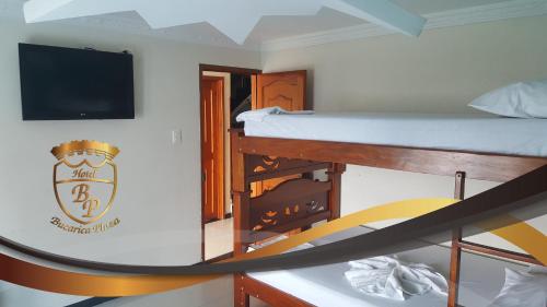 a room with a bunk bed and a flat screen tv at Hotel Bucarica Plaza in Bucaramanga