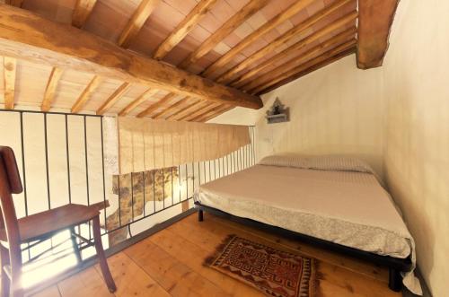 a small bedroom with a bed and a chair at Agriturismo il Casalino in Pari