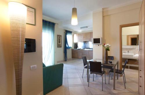 a living room and kitchen with a table and chairs at Posidonia Residence in Ischia