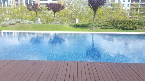 a large blue swimming pool with a wooden deck at The Galley in Lisbon
