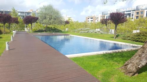 a wooden walkway leading to a swimming pool in a park at The Galley in Lisbon