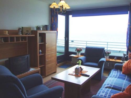 un salon avec deux chaises bleues et une télévision dans l'établissement Appartement Lohf, à Glücksburg