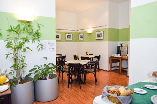 a restaurant with tables and chairs and plants at Pension Riedl in Vienna