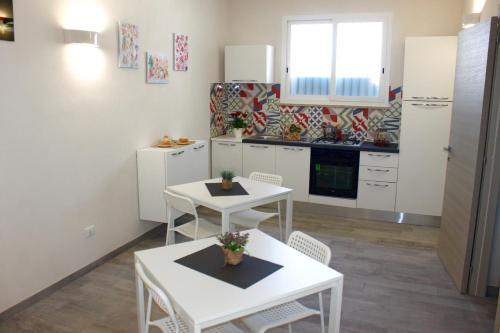a kitchen with white tables and white cabinets at Sirio Marsala in Birgi Vecchi