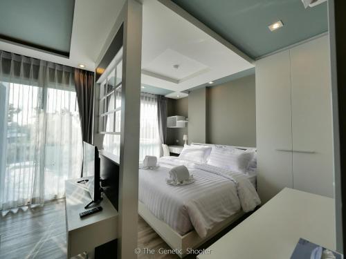 a bedroom with a white bed and a window at Wisdom Hotel & Residence in Rayong