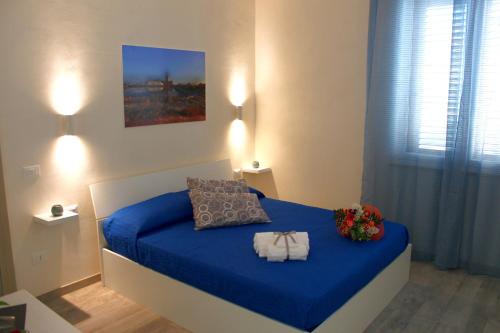 a bedroom with a blue bed with flowers on it at Sirio Marsala in Birgi Vecchi