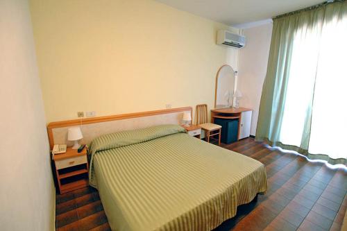 מיטה או מיטות בחדר ב-Hotel Paradiso Verde