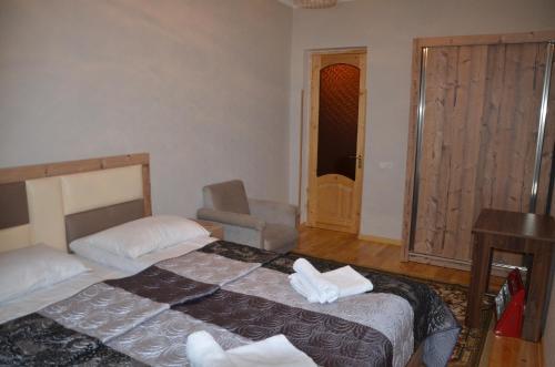 a bedroom with two beds and a chair in it at Light House Old City in Akhaltsikhe