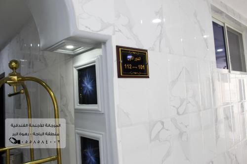 eine Uhr an der Wand neben einem Bad in der Unterkunft المرجانة للشقق المفروشه للعائلات Al Murjana Furnished Apartments for Families in Al Bahah