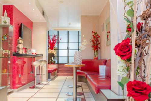 a living room with red furniture and red roses at Hotel Susa in Milan