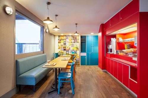 ブレティニー・シュル・オルジュにあるhotelF1 Brétigny sur Orgeの赤と青のキャビネット、テーブルと椅子が備わるレストラン
