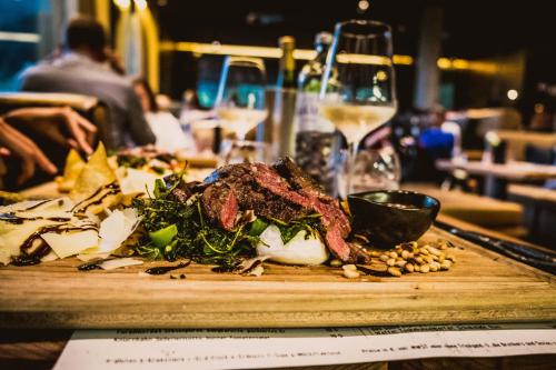 a plate of food on a table with a wine glass at mama thresl in Leogang