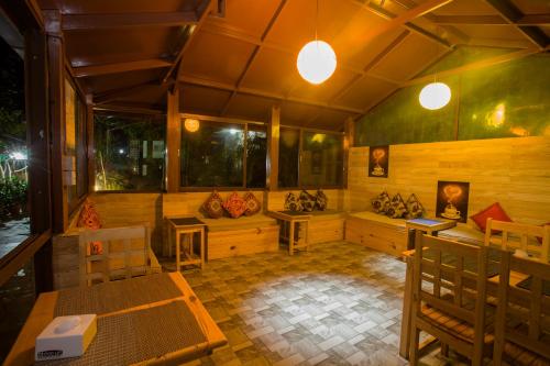 a large room with tables and chairs and windows at The North Face Inn in Pokhara