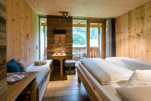 two beds in a room with wooden walls at mama thresl in Leogang