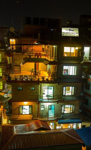 a tall building with lit windows at night at The North Face Inn in Pokhara