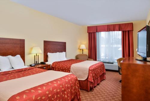 a hotel room with two beds and a flat screen tv at Americas Best Value Inn & Suites-Livingston in Livingston