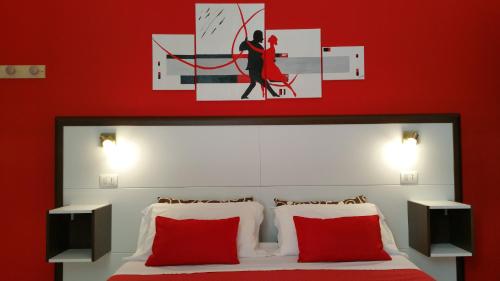 een slaapkamer met een bed met een rode muur bij Thea B&B in Acquedolci