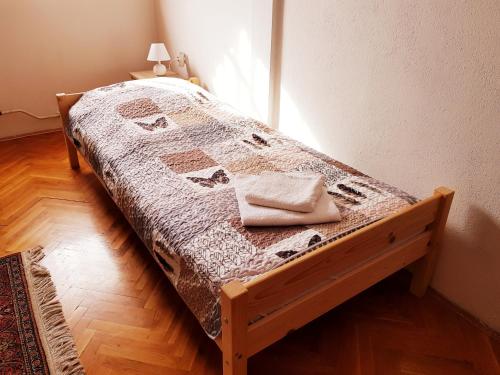 a bed with a quilt on it in a room at La Boheme Apartman in Miskolc