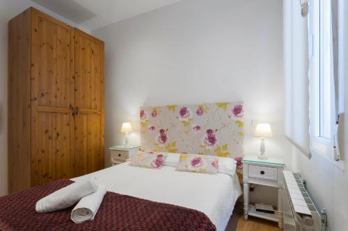 een slaapkamer met een wit bed met een bloemrijk hoofdeinde bij Cosy Apartment Malasaña in Madrid