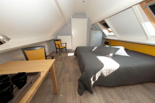 1 dormitorio con 1 cama, mesa y sillas en De Violier, en Eext