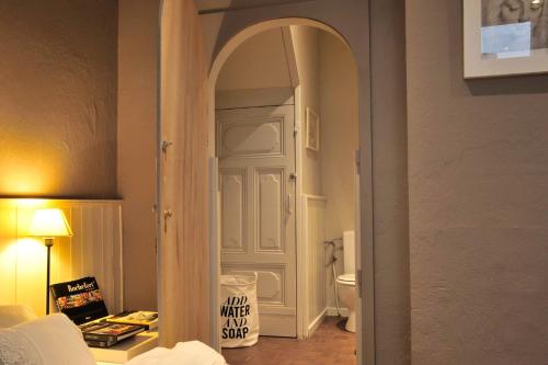 a room with a bathroom with a toilet and an open door at studio et appartement La Tête en l'Air in Durbuy